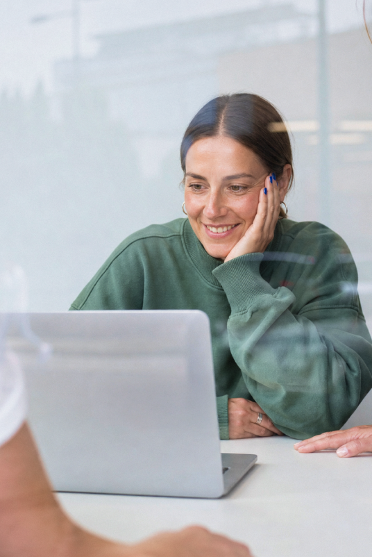 Nord Security employee smiling at her laptop in the office.
