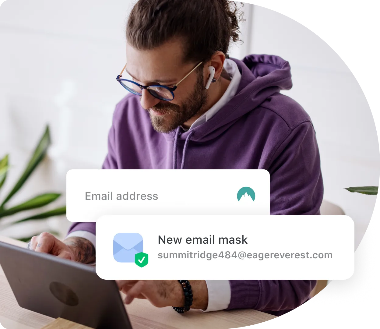 bearded person in purple hoodie using email masking on the laptop