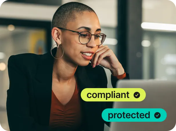 HIPAA Professional woman with glasses working on laptop, compliant and protected badges displayed