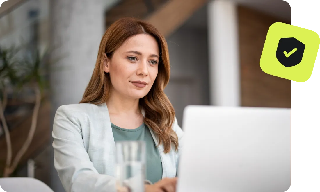 Woman working on a laptop with a security checkmark icon