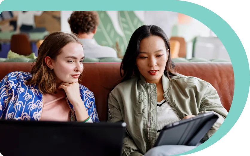 two women on sofa using nordpass on their ipad